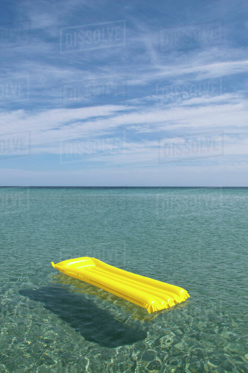 A yellow inflatable raft floating on the sea, Budoni, Sardinia, Italy ...