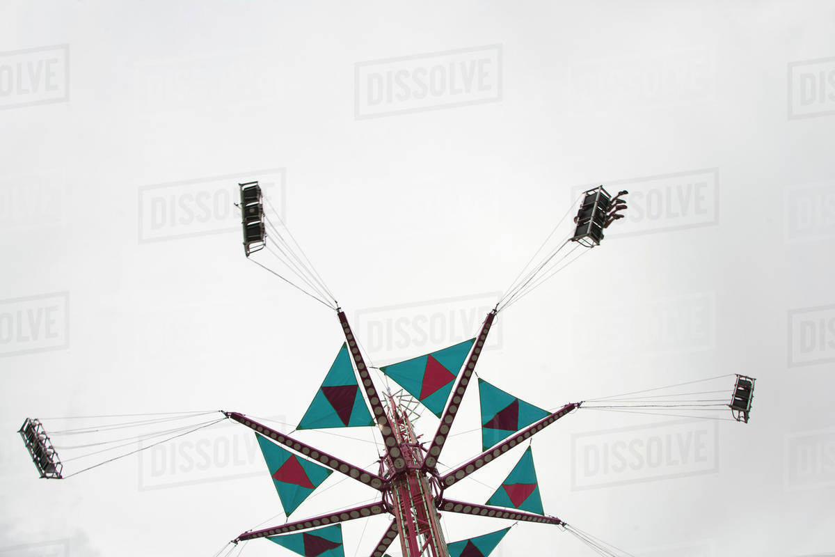 Low angle view of a fairground swing ride Stock Photo Dissolve