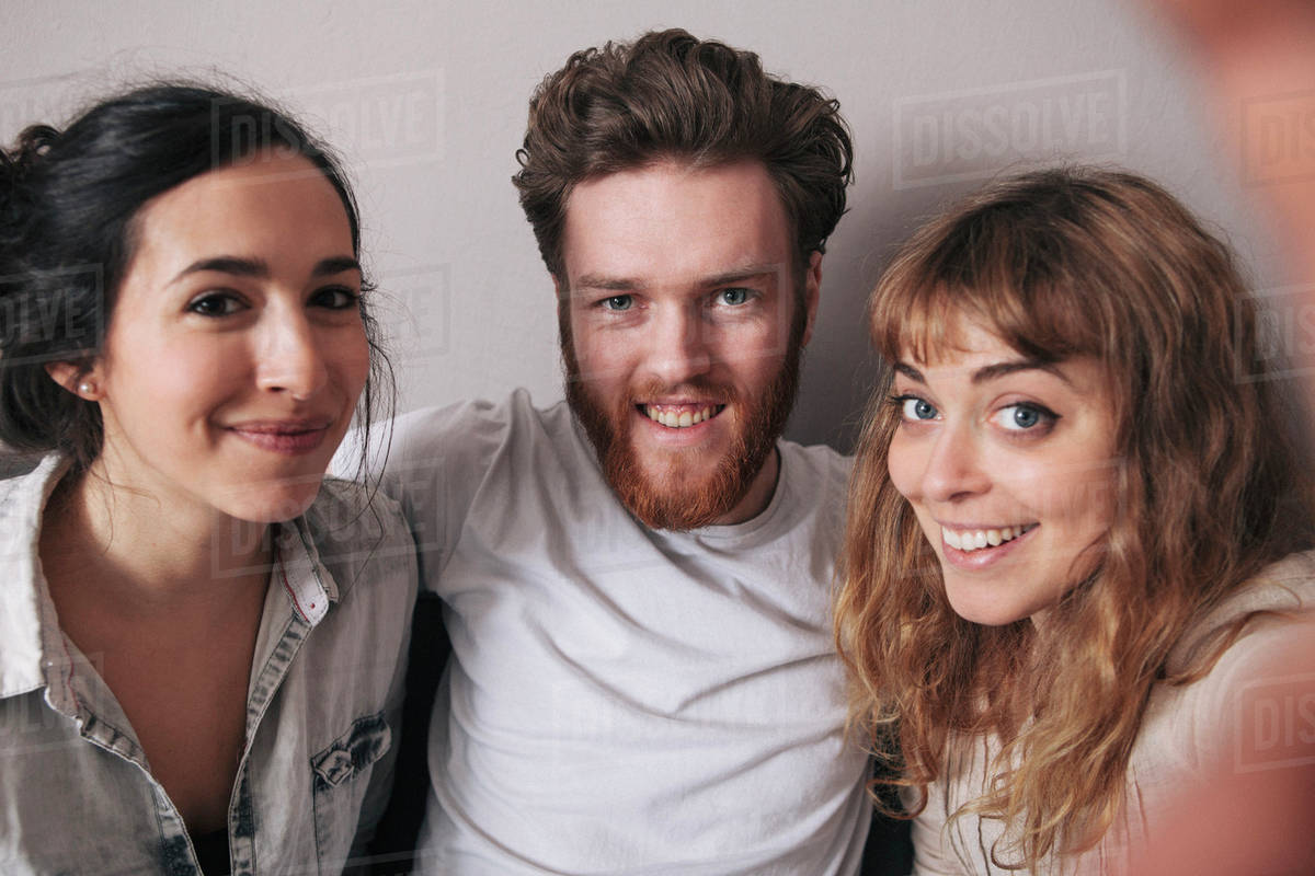 Portrait of smiling young man with female friends spending leisure time ...