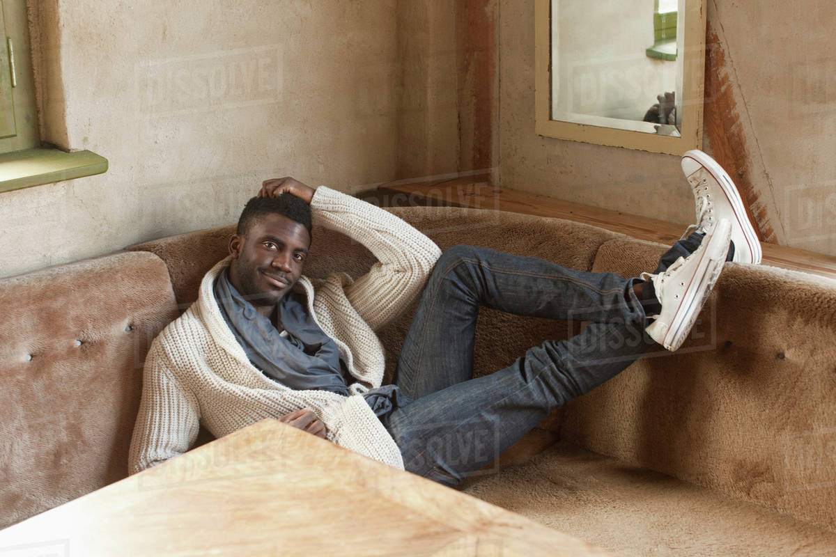 A stylish man reclining in a booth - Stock Photo - Dissolve
