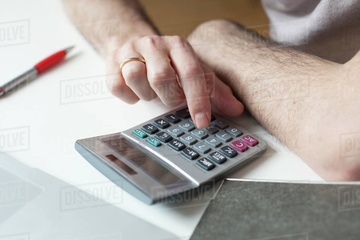cropped image of man using calculator at table stock photo dissolve