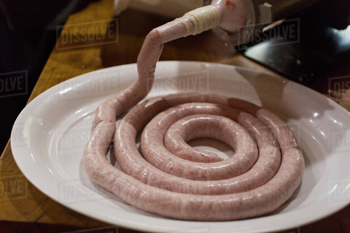 Closeup of sausage being processed in machinery Stock Photo Dissolve