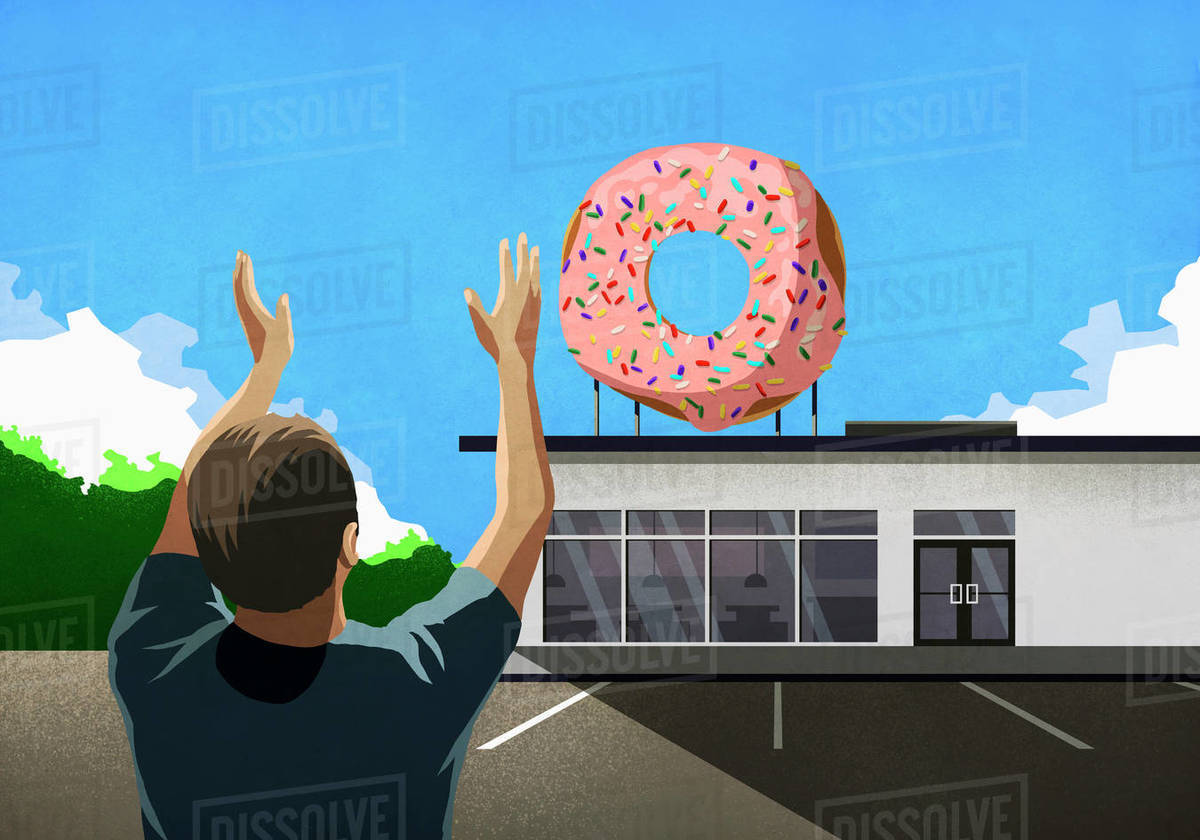 Man with arms raised looking up at pink donut on top of bakery Royalty-free stock photo