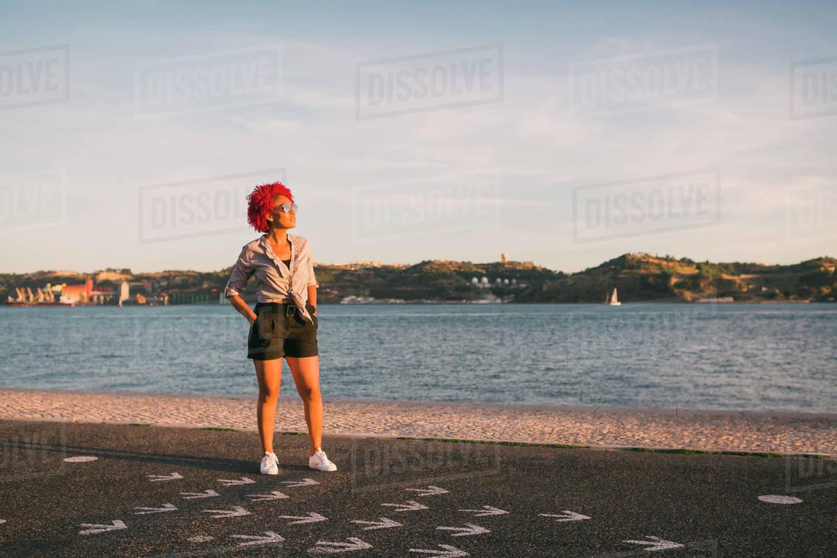 Portrait stylish woman standing at sunny waterfront, Tagus River, Portugal Royalty-free stock photo