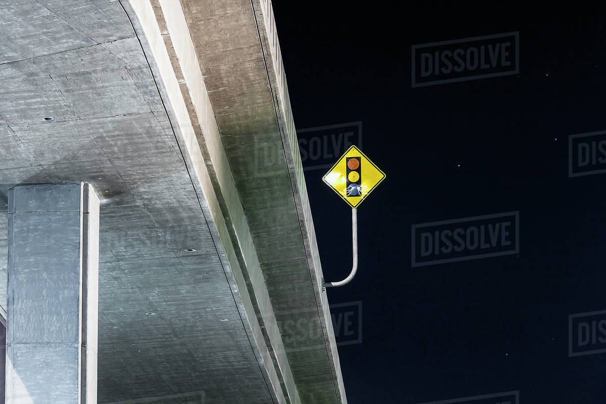 Stoplight sign on highway bridge under night sky Stock Photo Dissolve