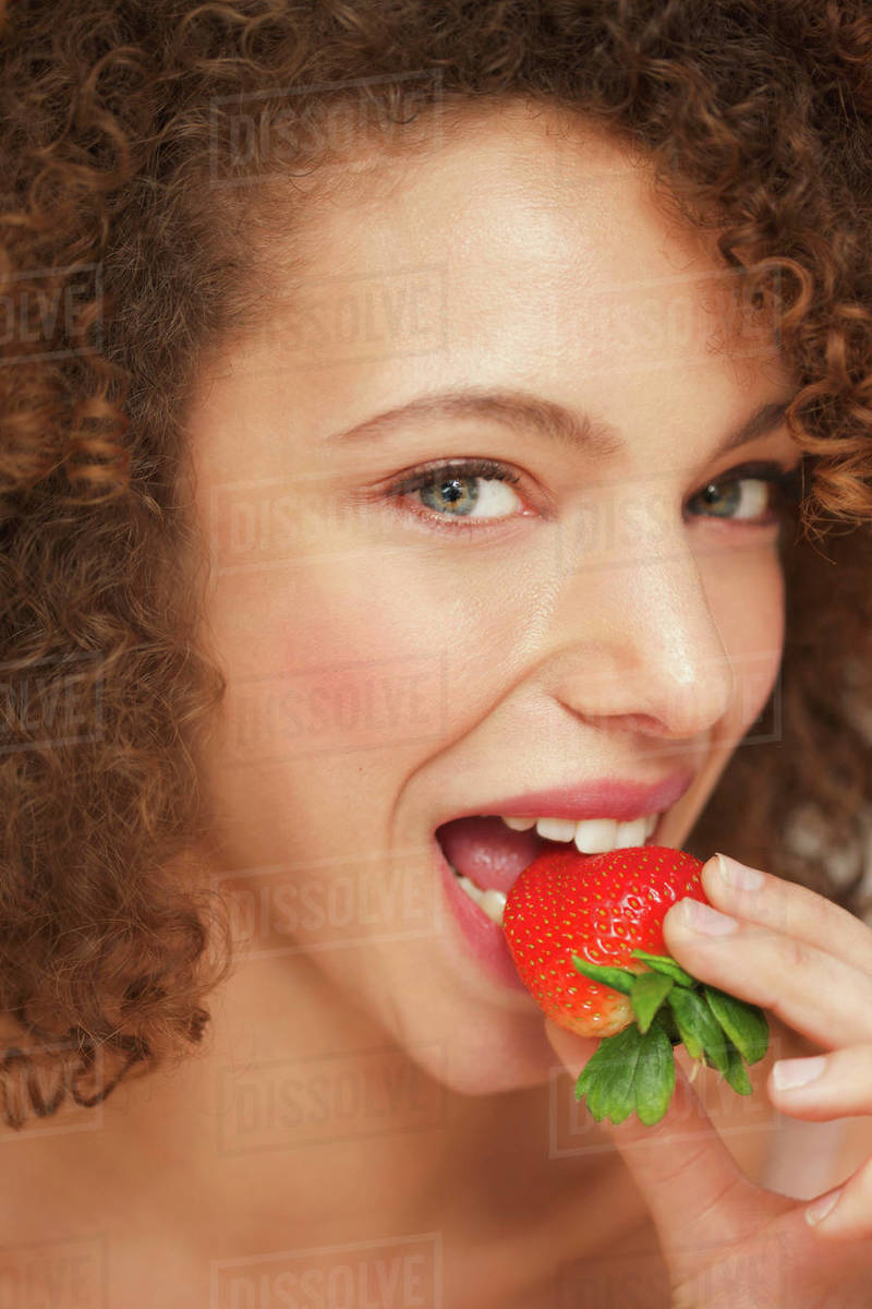 Close up of Woman Biting Strawberry - Royalty-free Stock Photo | Dissolve